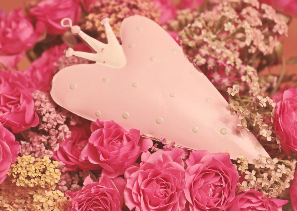 Beautiful, pink and white heart with the crown, among the pink roses