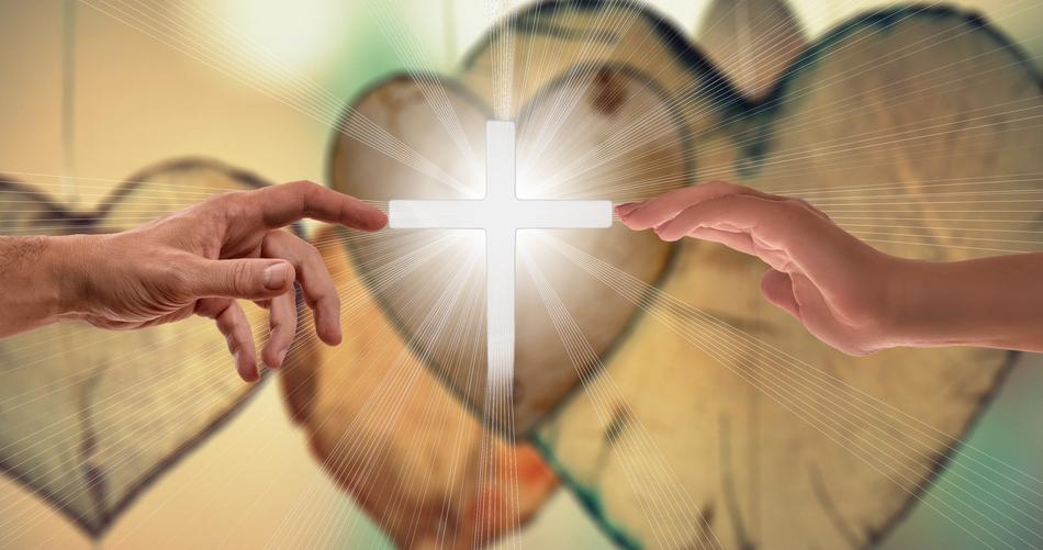 two hands reach for the luminous cross