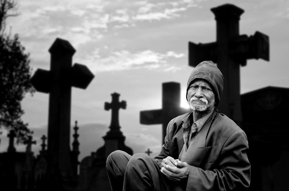 black and white photo of an elderly man in a cemetery