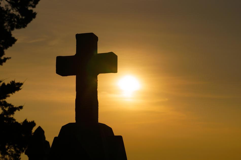 stone cross against the setting sun