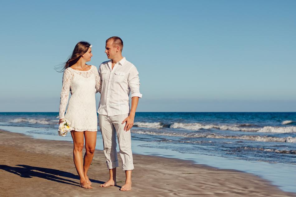 newlyweds walk along the seashore