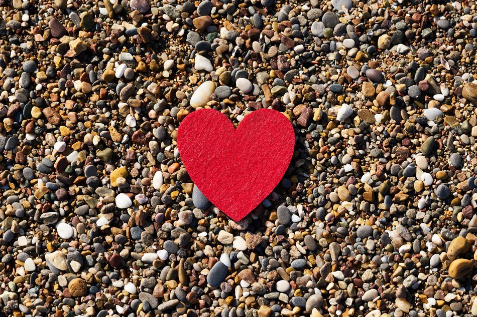 Beautiful, red, soft heart sign, on the colorful pebbles