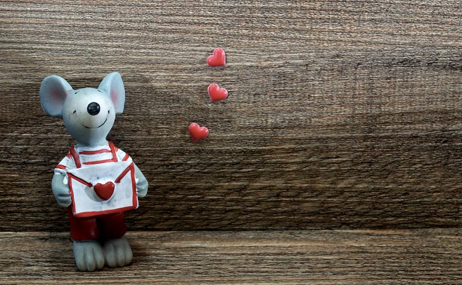 ceramic mouse with a letter on a wooden background