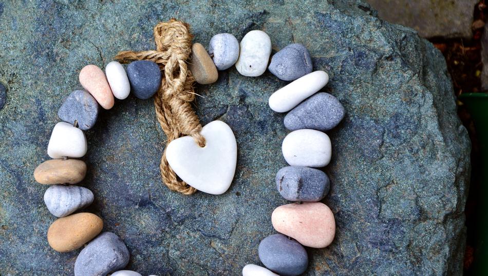 Beautiful and colorful stones with heart and cord, on the rock