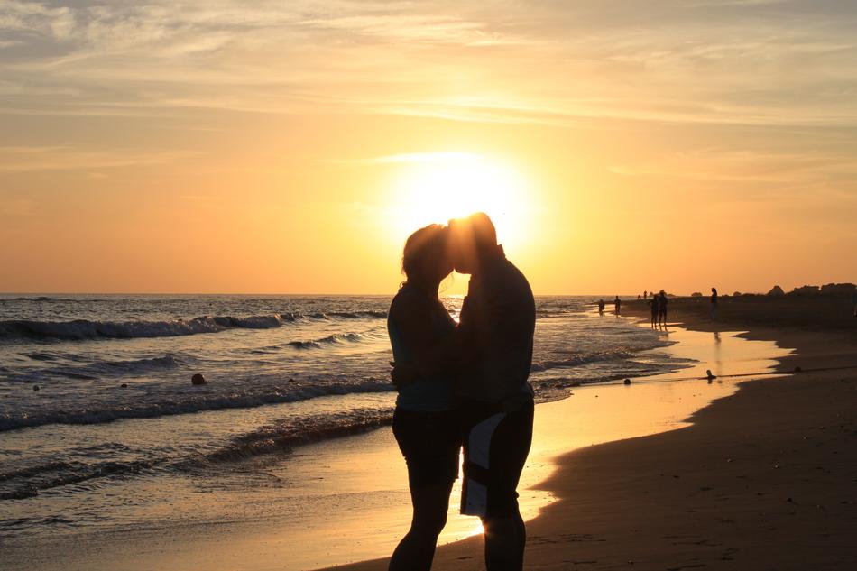 couple in love kissing on the seashore during sunset