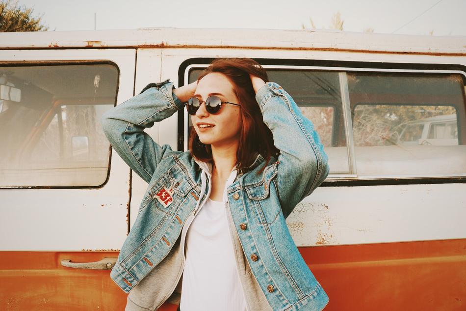 positive girl near the old car