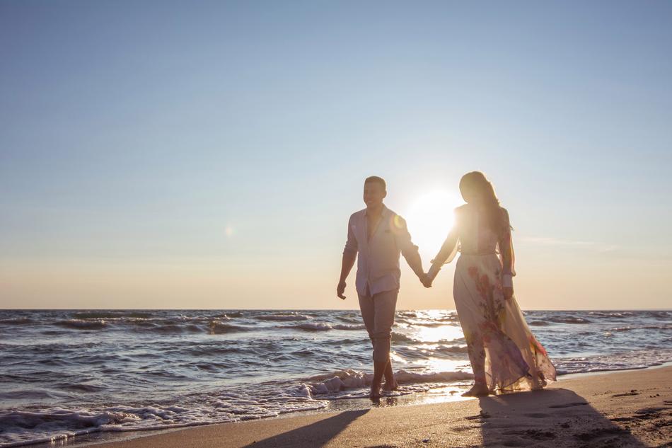 Couple in Love walking along surf line at sunset