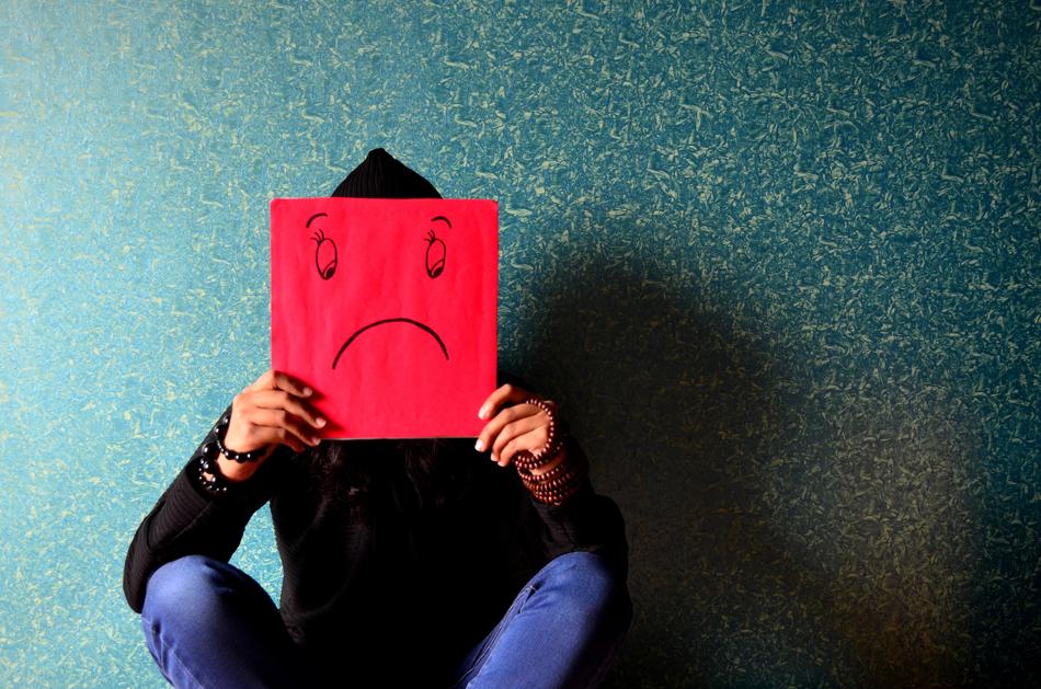 Unhappy Man with the red and black Mask at colorful wall background