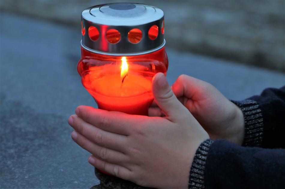 photo of a burning candle in the hands of a child