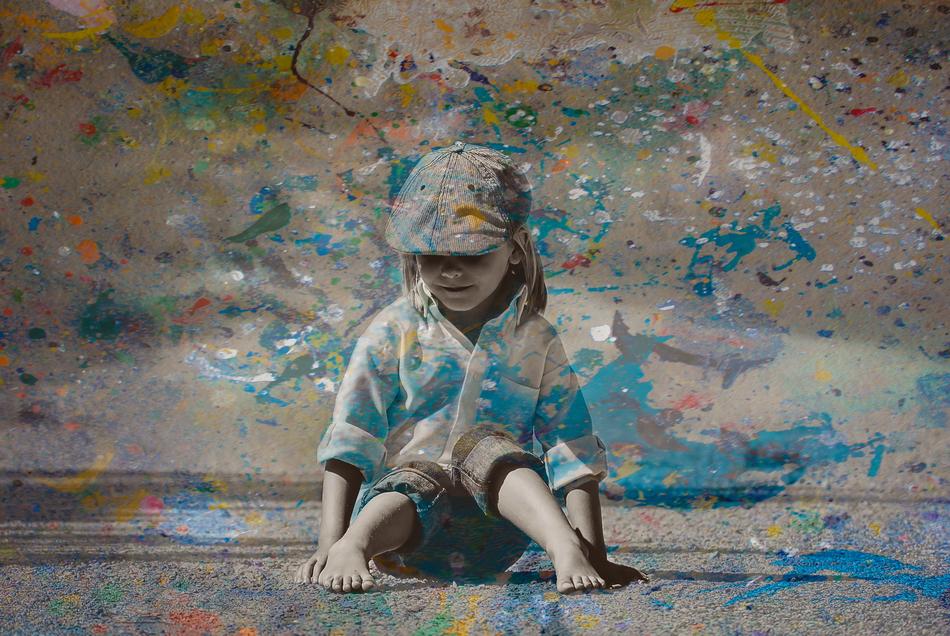 Child in blue Paint sits on Ground