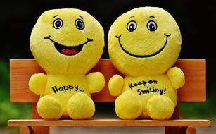 plush Smilies toys on a bench