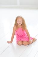 pretty caucasian child Girl sits on floor