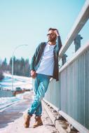 stylish young Man stands at fence