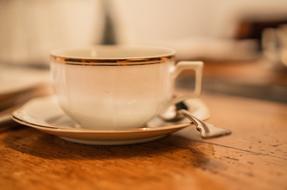 vintage Coffee Cup and spoon on saucer on wooden table