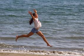 photo of a happy girl running on the beach