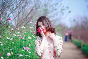 photo of a cute asian girl on a background of flowers in the park