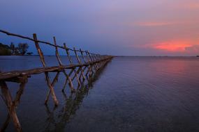 long weathered wooden pier in sea at tranquil sunset, Vietnam, Phu Quoc