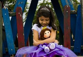 girl in princess dress with a doll