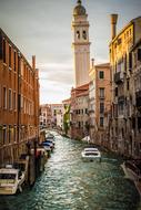 landscape of a boat sailing along a canal in Venice, Italy