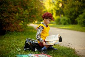 boy reading a book in park