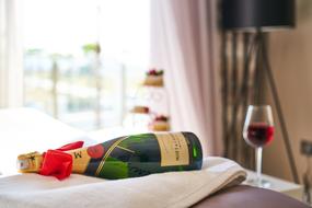 Wine bottle and glass and Fruits in Bed in hotel