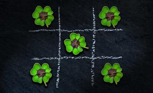 Beautiful, green four leaf clovers, on the black and white, checkered background