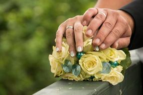 Wedding couple hands on bouquet