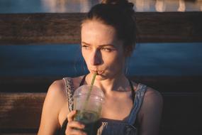 woman drinking from plastic cup