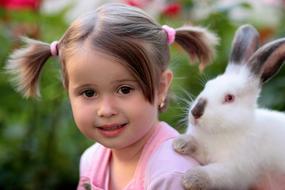 little girl with a white rabbit on a blurred background