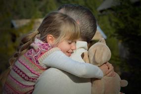 daughter hugs father when meeting