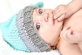 Portrait of the cute, laying child, in the colorful hat