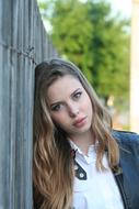 beautiful girl near the fence on a blurred background