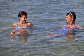 Couple, swimming in the Bodensee, with light reflection