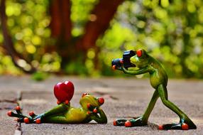 Beautiful and cute, green and yellow frog figures on the road