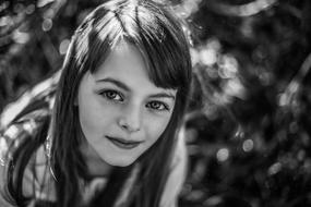 black and white portrait of a little beautiful girl on a blurred background