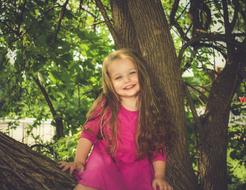 happy little girl on a big tree