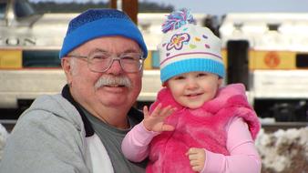 happy grandfather holding granddaughter in his arms