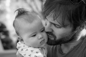 young Man kissing Baby