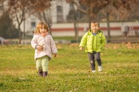 two children play in the garden in autumn