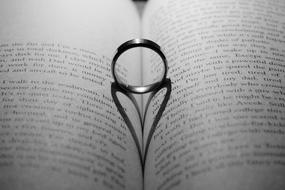 Love symbol, Ring with heart shape shadow on open book