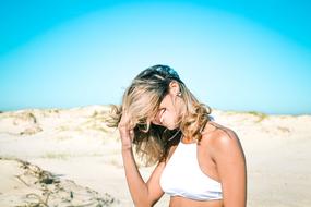 happy blonde among the sand dunes in the wind