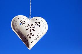 Beautiful, white, patterned heart, at blue sky on background