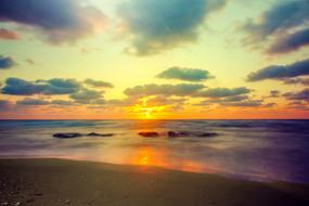 sunset in the clouds over a quiet coast