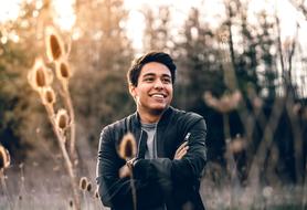 happy guy among the grass in a blurred background