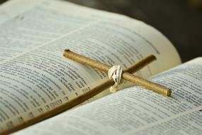 wooden cross lies on holy scripture