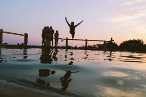 fun jumping into water at dusk