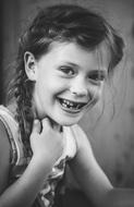 Black and white photo of the portrait of the smiling girl with plaits