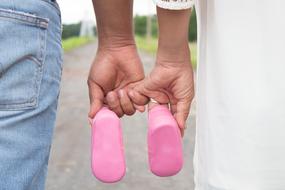 parents with pink booties for their daughter