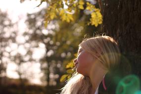 girl sitting near a tree in summer