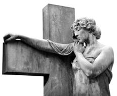 sculpture near the large cross in black and white background